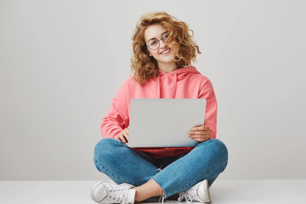 girl in a pink sweatshirt doing research for back to school stuff