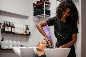 hair stylist washing client's hair