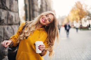 girl smiling and wearing a yellow hoodie