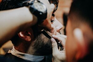 Barber shaving clients beard